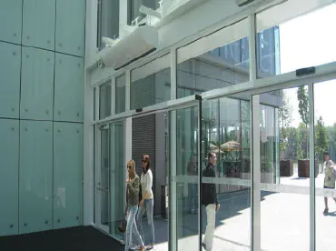 People walking through automatic doors to enter a building