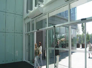 People walking through automatic doors to enter a building