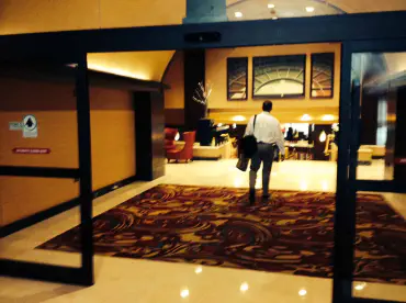 Man entering a hotel lobby through automatic doors