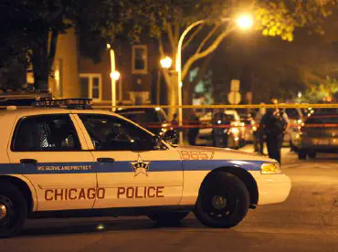 Chicago police car at a crime scene with it blocked off with tape.