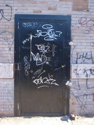 An exterior warehouse door covered in graffit