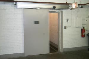 A large door on a track against a wall sliding open