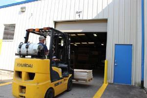 Man operating a forklift though a door