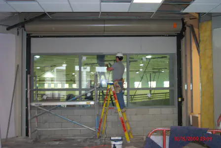 worker installing a rolling fire door