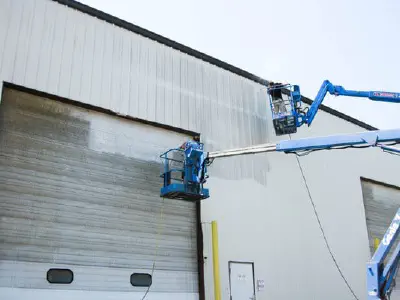 Men in bucket trucks pressure washing commercial garage doors