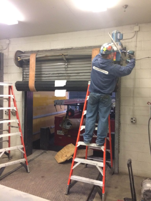 industrial door company repairman working on automatic door