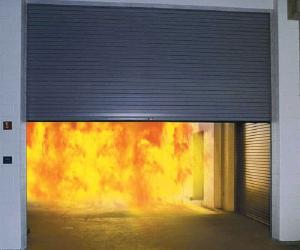 roll-up fire door half open to show fire behind it