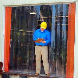 A man standing outside of a vinyl strip door.