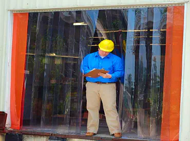 man standing in front of a vinyl strip door